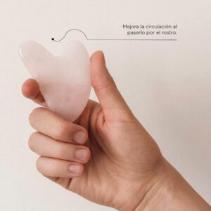 Persona sosteniendo en la mano una guasha facial de cuarzo de Botica 44
